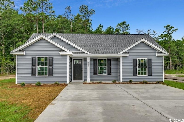 ranch-style home featuring a front yard and roof with shingles