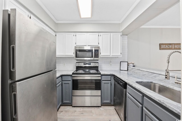 900 N Waccamaw Dr Unit 303, Murrells Inlet, SC 29576 - kitchen with stainless steel appliances, gray cabinets, light stone countertops, light wood-style flooring, and ornamental molding