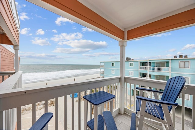 balcony featuring a water view and a beach view