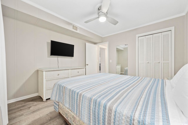 bedroom featuring visible vents, light wood-style flooring, ceiling fan, ornamental molding, and a closet