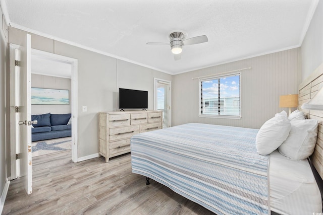 bedroom featuring ceiling fan, a textured ceiling, baseboards, ornamental molding, and light wood-type flooring