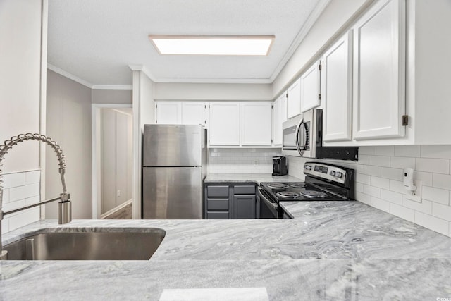 900 N Waccamaw Dr Unit 303, Murrells Inlet, SC 29576 - kitchen with appliances with stainless steel finishes, tasteful backsplash, white cabinets, light stone counters, and crown molding