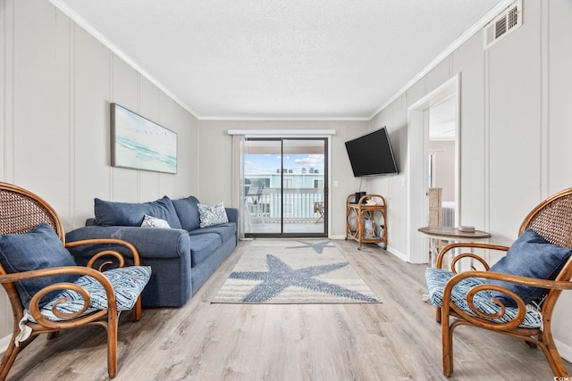 900 N Waccamaw Dr Unit 303, Murrells Inlet, SC 29576 - living room with crown molding, wood finished floors, a decorative wall, and a textured ceiling