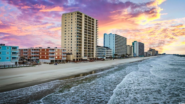 view of property with a view of the beach, a view of city, and a water view