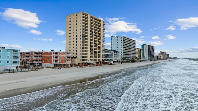 view of property featuring a view of the beach and a city view