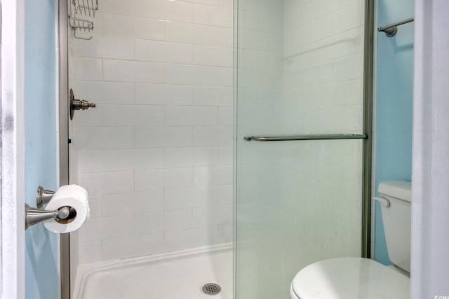 bathroom featuring a stall shower and toilet