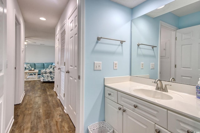 bathroom with ceiling fan, recessed lighting, wood finished floors, and vanity