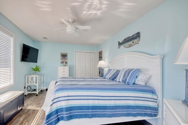 bedroom with a closet, multiple windows, visible vents, and wood finished floors