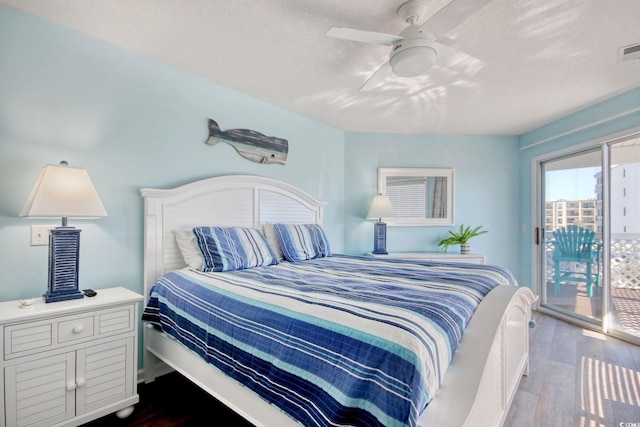 bedroom featuring dark wood finished floors, access to outside, visible vents, and a textured ceiling