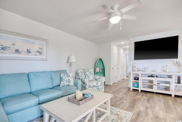 living area with a textured ceiling, recessed lighting, wood finished floors, and ceiling fan