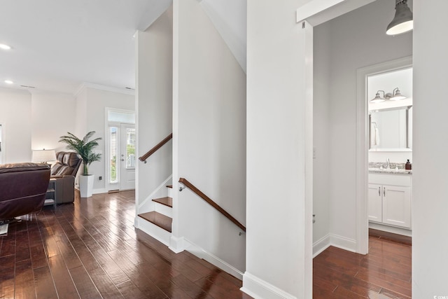 hall with recessed lighting, dark wood-type flooring, a sink, baseboards, and stairway