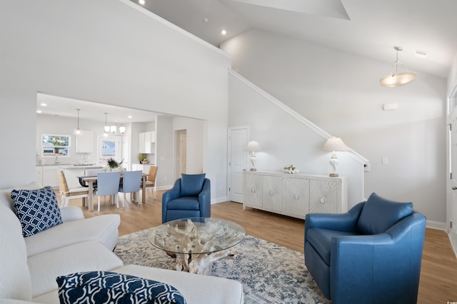 living area featuring baseboards, light wood finished floors, and high vaulted ceiling