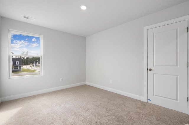 carpeted empty room with recessed lighting, visible vents, and baseboards