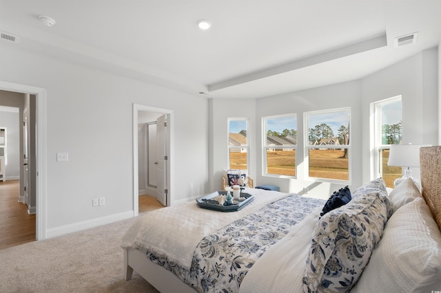 carpeted bedroom featuring recessed lighting, baseboards, multiple windows, and visible vents