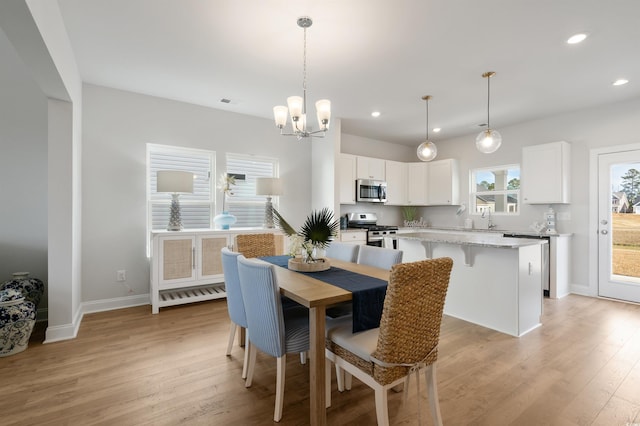 dining area with a chandelier, recessed lighting, and light wood-style flooring