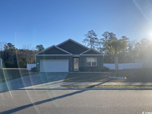 view of front facade featuring driveway, an attached garage, and fence