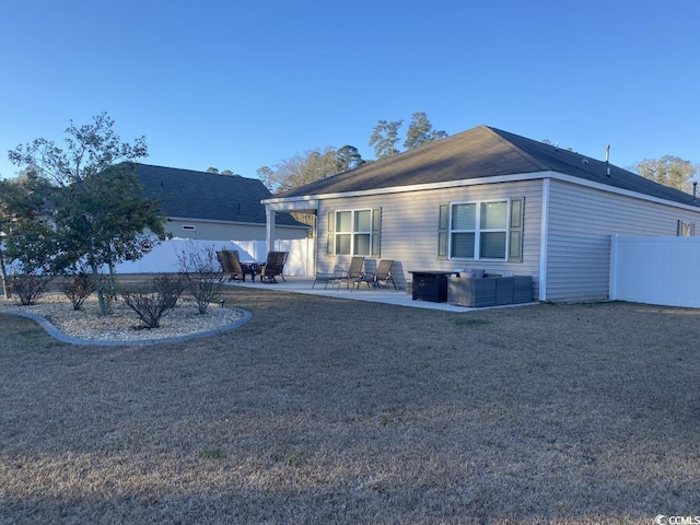 view of side of home featuring a patio area, fence, and a lawn