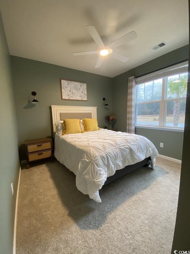 carpeted bedroom featuring baseboards, visible vents, and ceiling fan