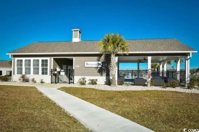 rear view of property with a lawn and fence