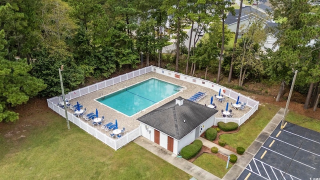 community pool featuring a yard, fence, and a patio