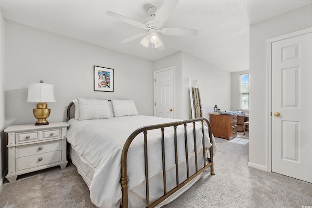 bedroom with light colored carpet, ceiling fan, and a textured ceiling