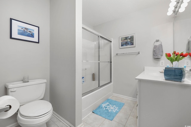 bathroom with baseboards, toilet, tile patterned floors, combined bath / shower with glass door, and vanity