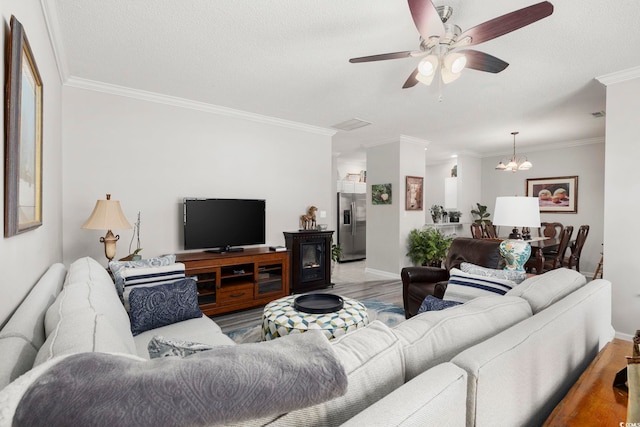 living area with crown molding, baseboards, wood finished floors, and ceiling fan with notable chandelier