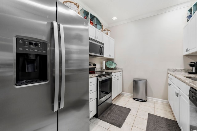 kitchen with light stone counters, stainless steel appliances, crown molding, white cabinetry, and light tile patterned flooring