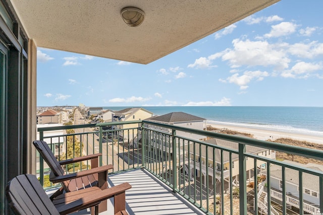 balcony with a water view and a view of the beach