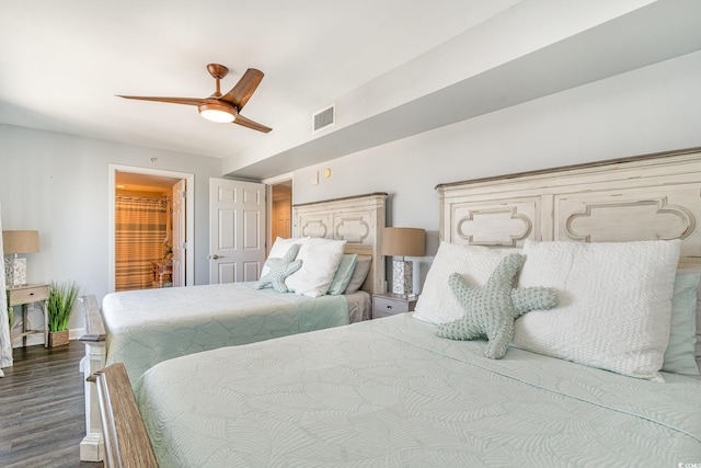 bedroom with ceiling fan, visible vents, baseboards, dark wood-style floors, and ensuite bath