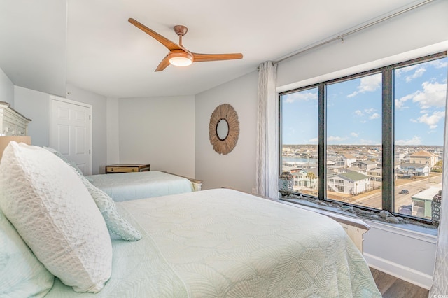 bedroom featuring ceiling fan, baseboards, and wood finished floors