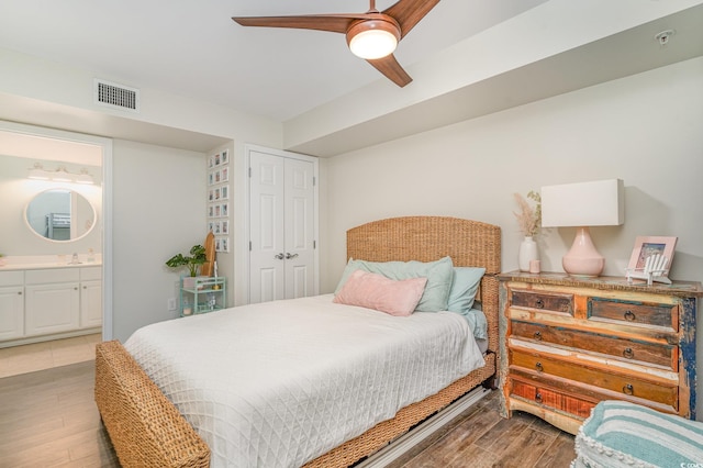 bedroom featuring visible vents, a ceiling fan, connected bathroom, wood finished floors, and a closet