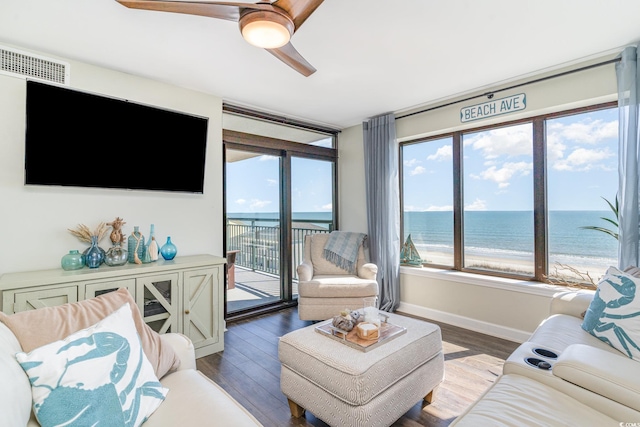 living room with a water view, ceiling fan, visible vents, and wood finished floors