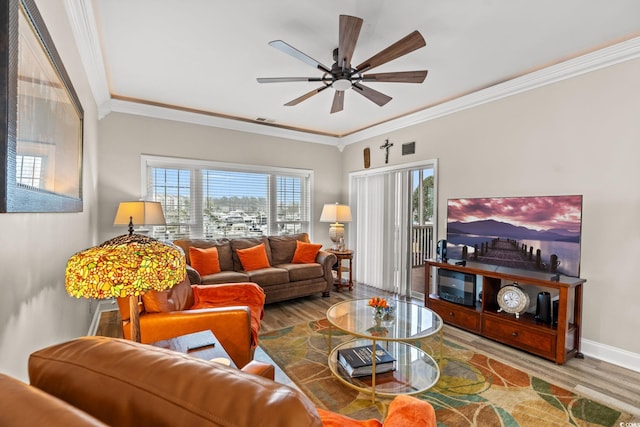 living room with a healthy amount of sunlight, visible vents, baseboards, and wood finished floors