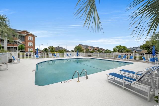 pool with a residential view, fence, and a patio