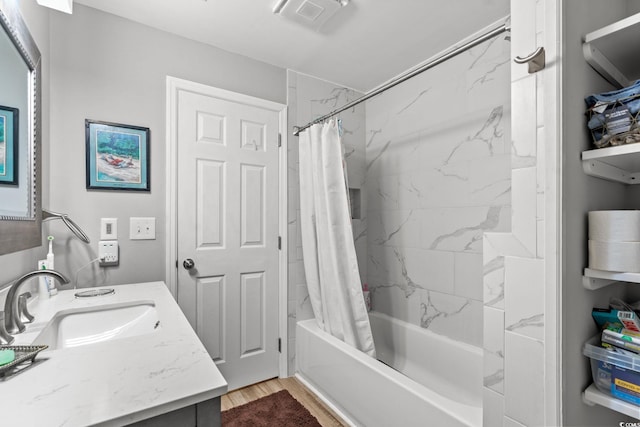 bathroom featuring visible vents, shower / bath combo, wood finished floors, and vanity