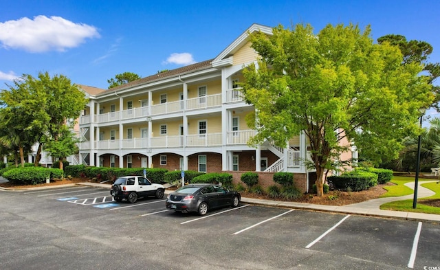 view of property featuring stairs and uncovered parking