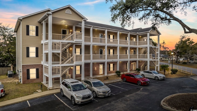 view of building exterior featuring uncovered parking and central AC unit