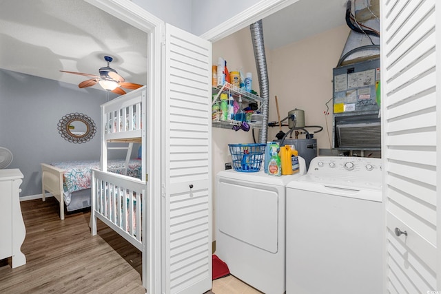 clothes washing area featuring ceiling fan, light wood-style flooring, laundry area, baseboards, and washer and dryer