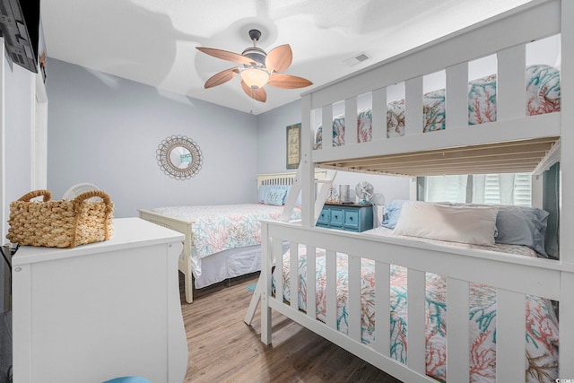 bedroom with ceiling fan, light wood finished floors, and visible vents