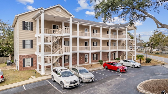 view of property with uncovered parking and central AC unit