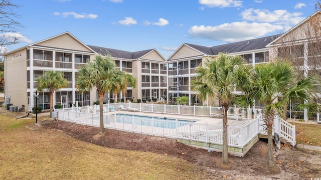 community pool featuring a patio area, fence, and cooling unit