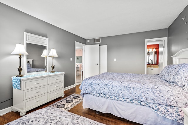 bedroom featuring dark wood-type flooring, visible vents, connected bathroom, and baseboards