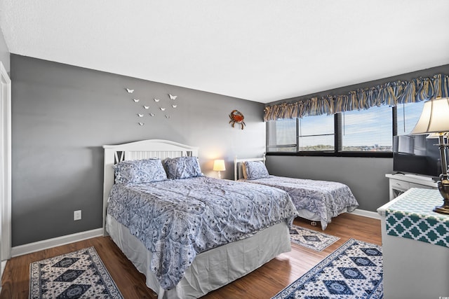 bedroom with baseboards and wood finished floors