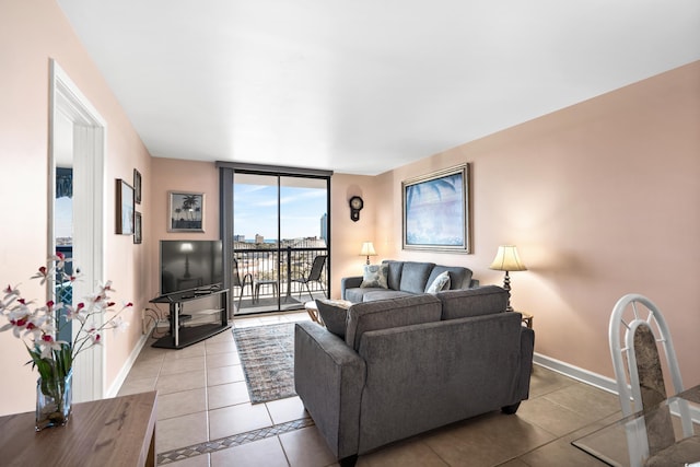 living area with expansive windows, light tile patterned flooring, and baseboards