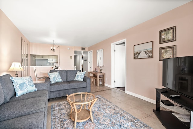 living room featuring baseboards, tile patterned flooring, visible vents, and a notable chandelier