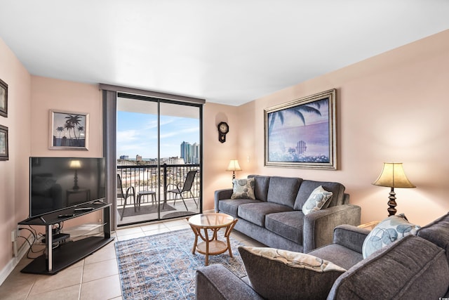 living room featuring light tile patterned floors, baseboards, and a wall of windows