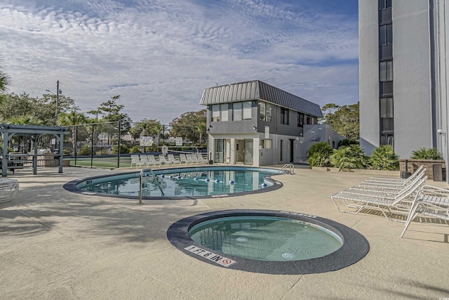 pool featuring a patio area, a hot tub, and fence