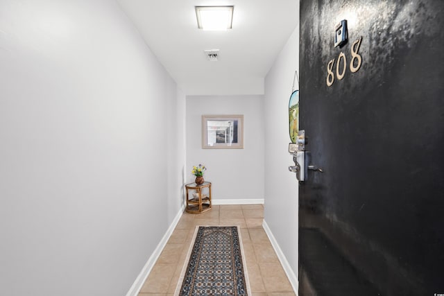 doorway to outside with light tile patterned floors, visible vents, and baseboards