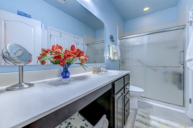 full bath featuring toilet, a stall shower, vanity, and tile patterned floors